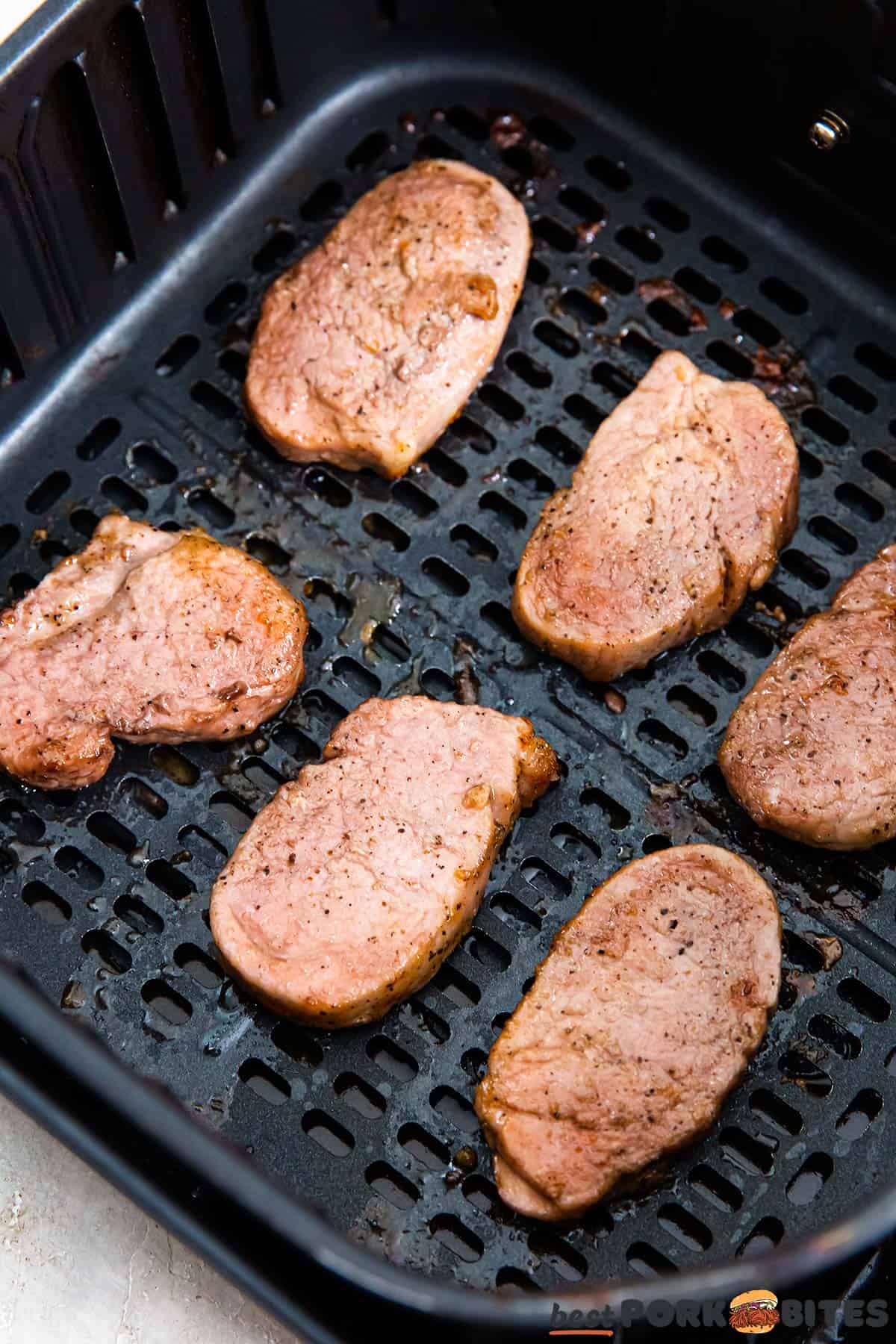 cooked pork medallions in an air fryer basket