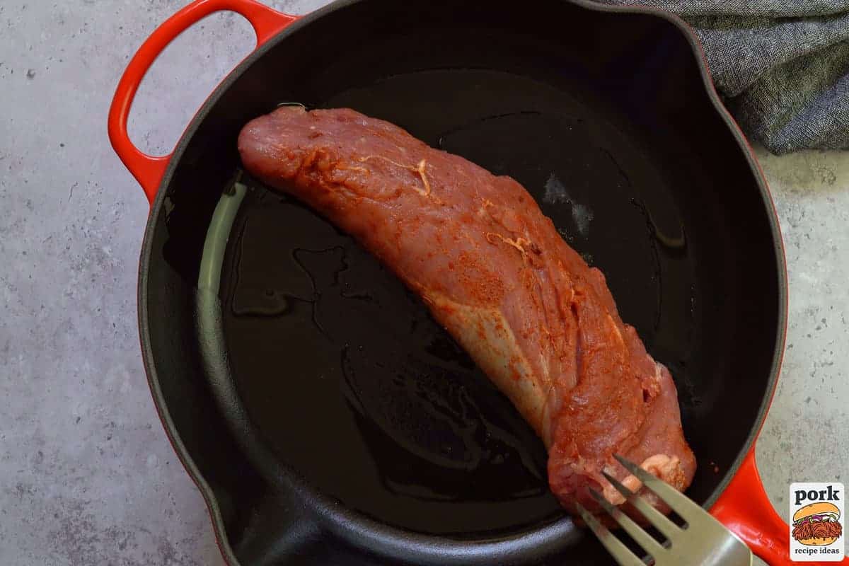 pork tenderloin added to pan with oil