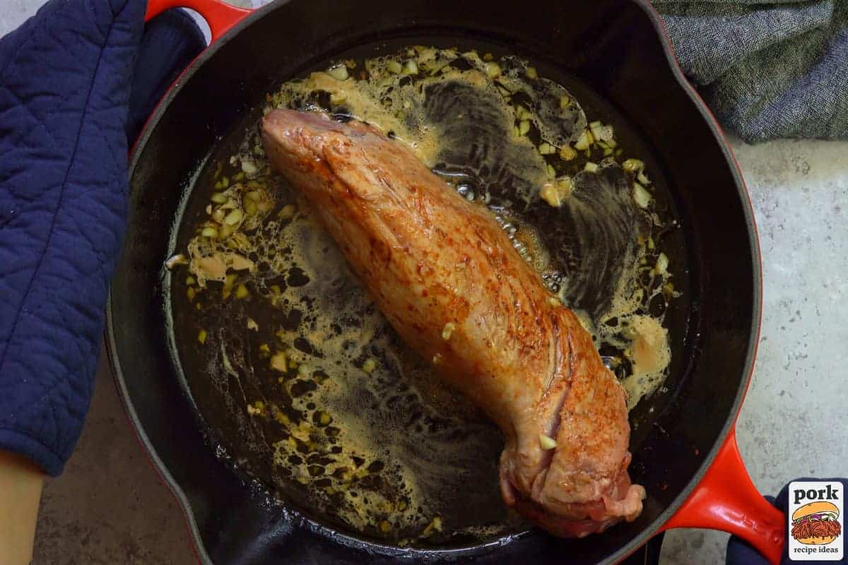 pork tenderloin in pan with garlic sauce