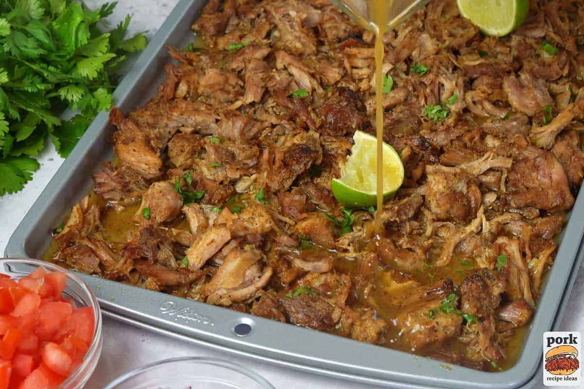 baked carnitas with the sauce being poured over top