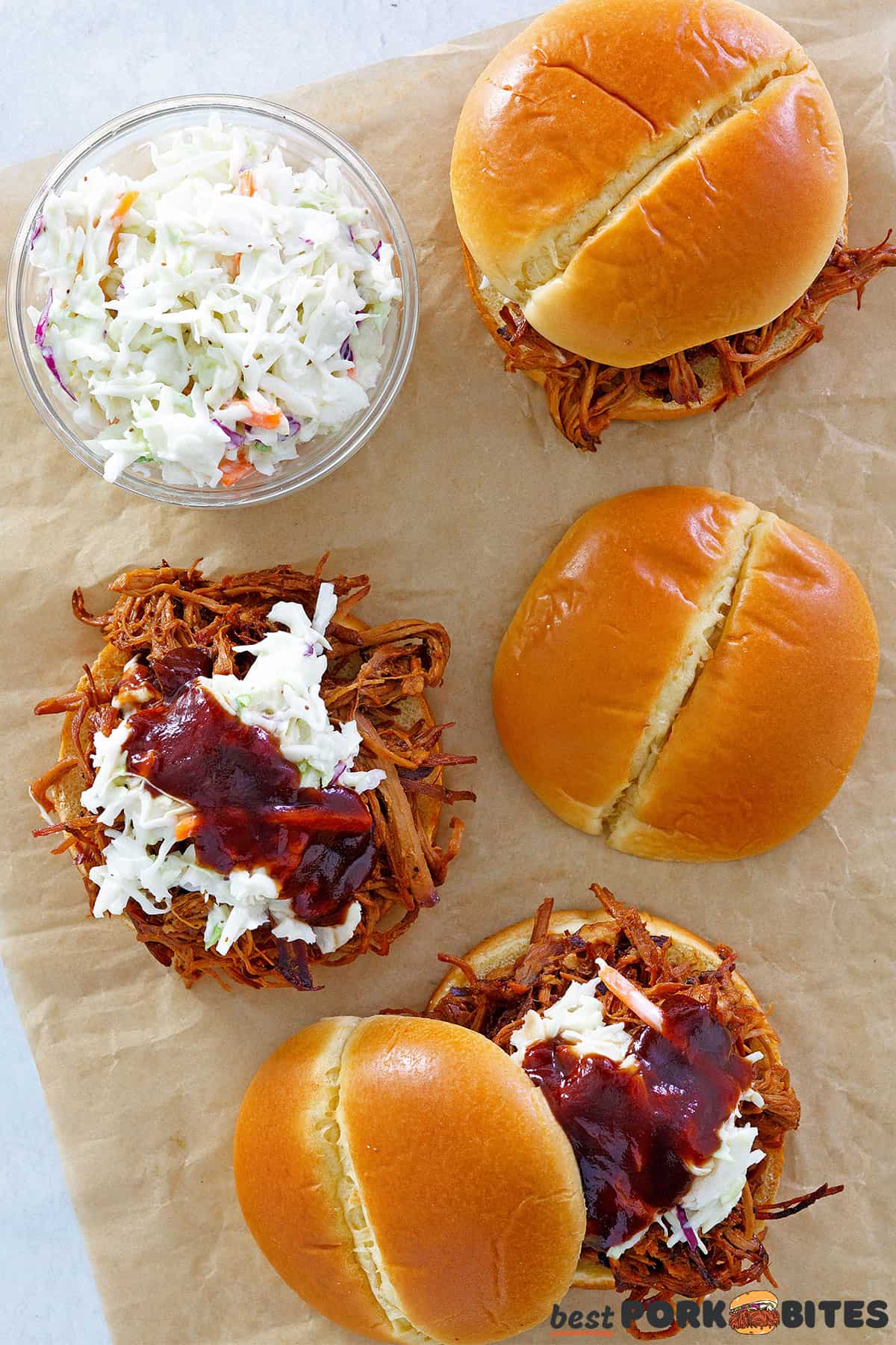 three slow cooker pulled pork sandwiches with coleslaw and bbq sauce