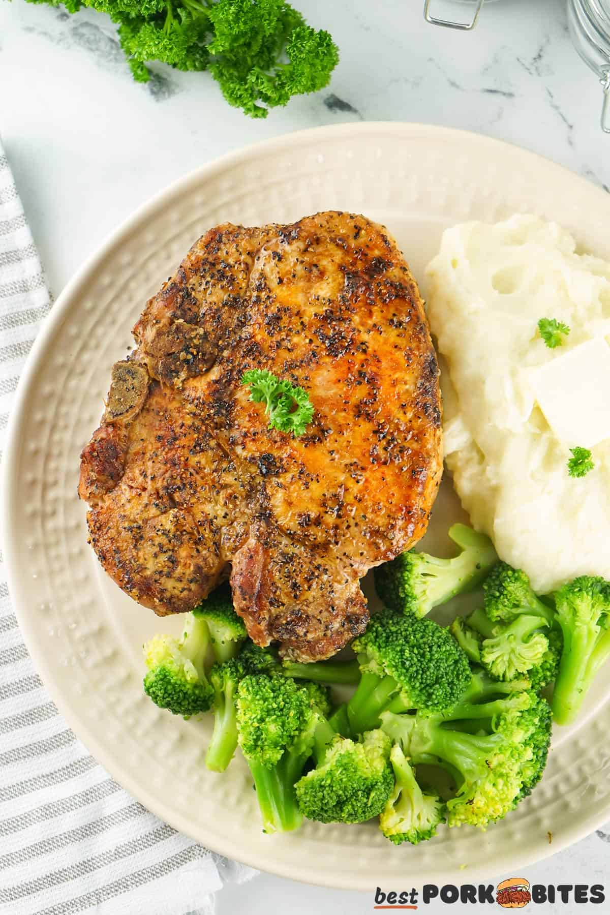 grilled pork chop on a plate with broccoli and mashed potatoes