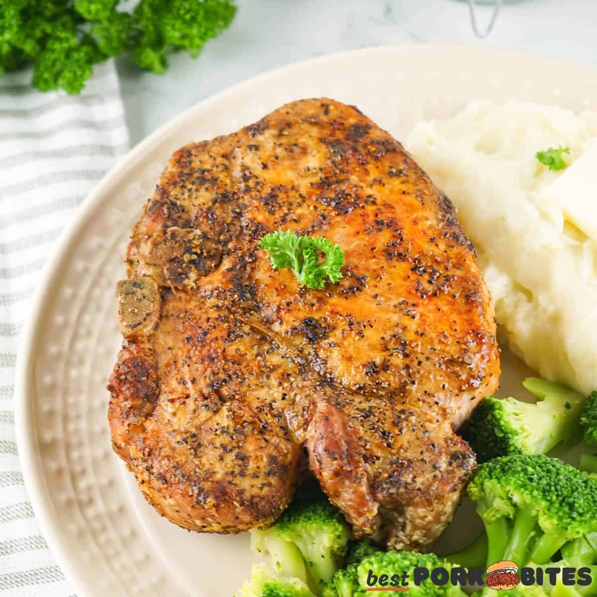 grilled pork chop on a plate with broccoli and mashed potatoes