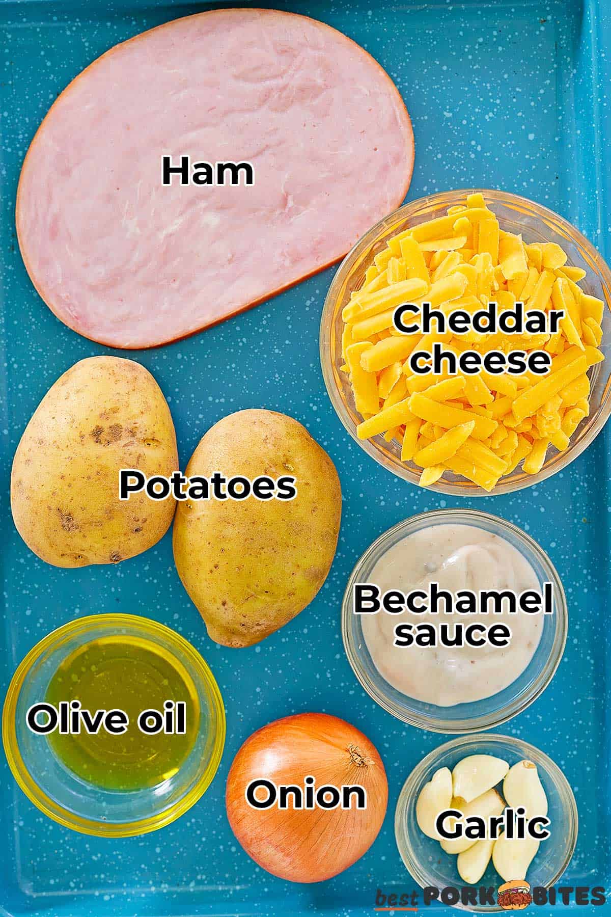 the ingredients for ham and cheese casserole laid out on a blue baking tray, with labels