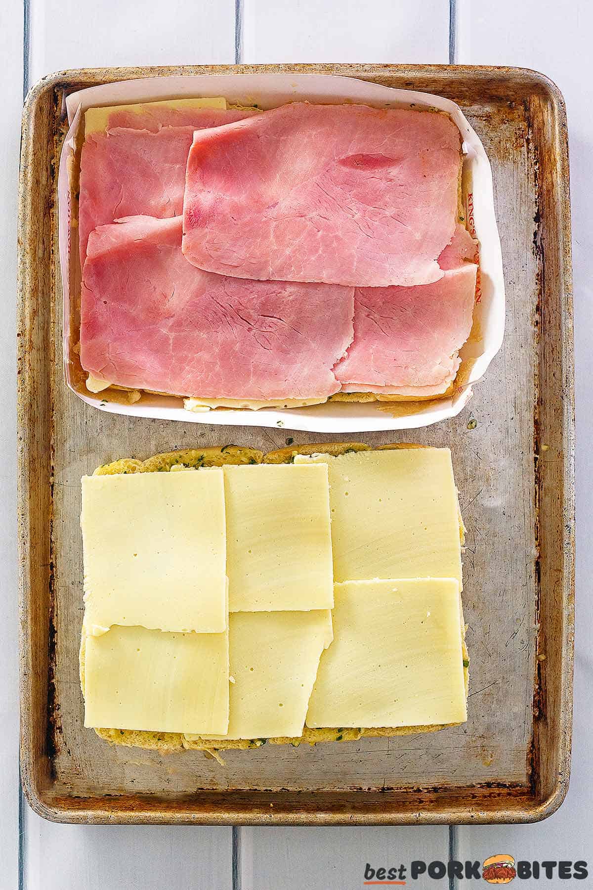 hawaiian rolls layered with ham and cheese on a baking tray
