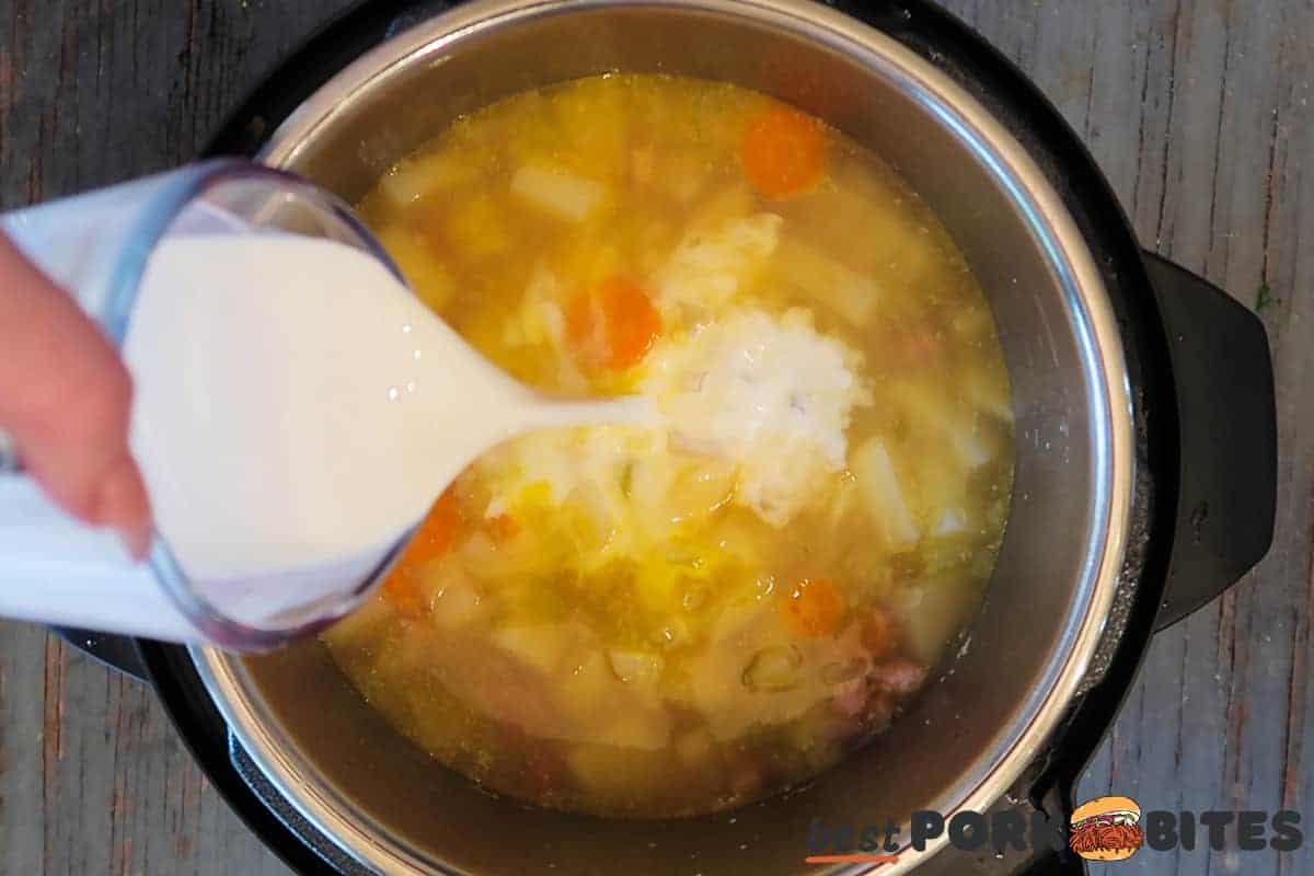 cream being poured into an instant pot of ham and potato soup