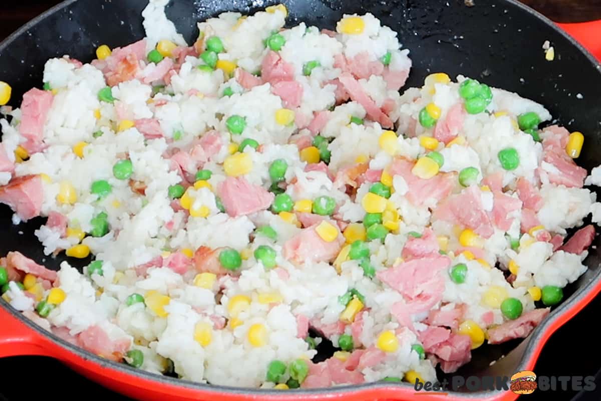 rice, ham, frozen peas and corn in a skillet