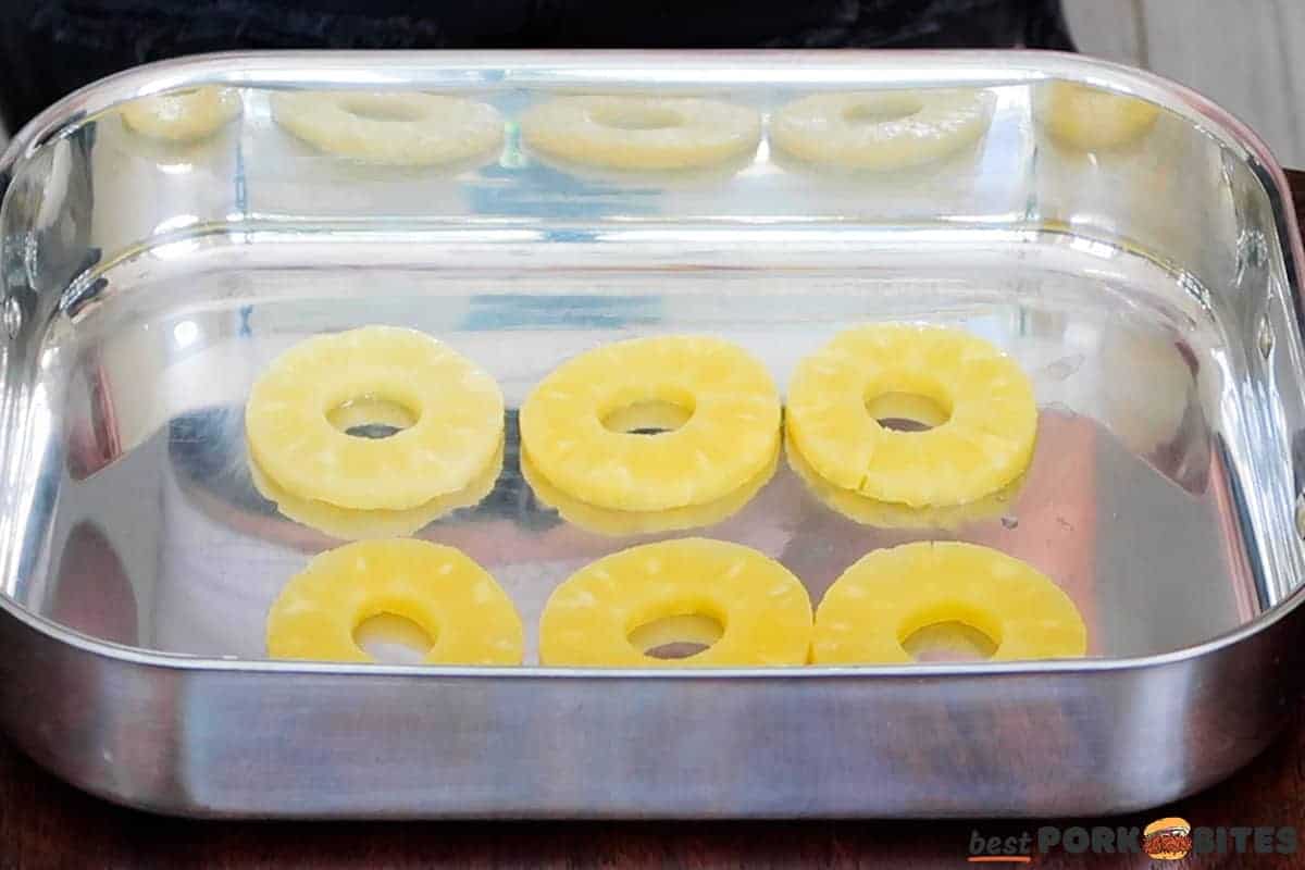 pineapple rings arranged in a metal baking dish