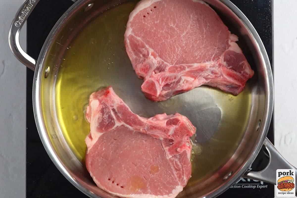 pork chops added to the pan with oil
