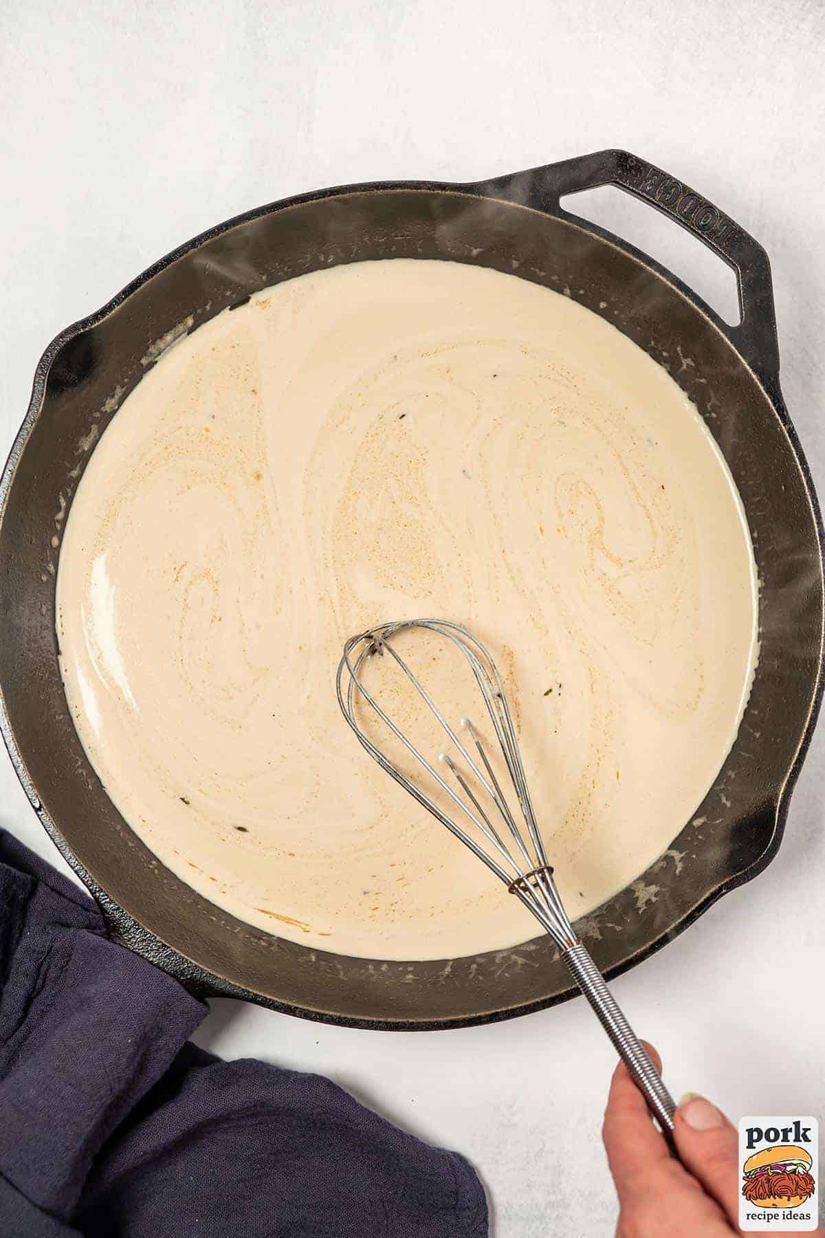mustard sauce being whisked in a pan