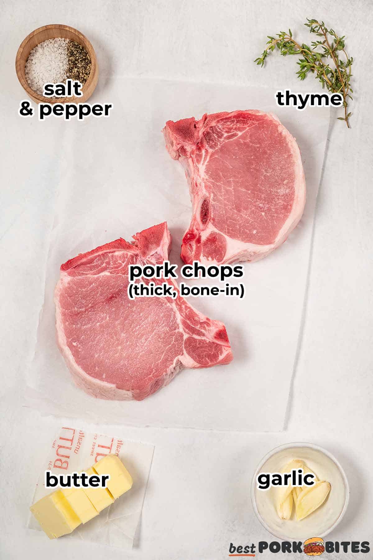 ingredients to pan fry pork chops: pork chops, salt and pepper, thyme, butter, and garlic, on a white surface