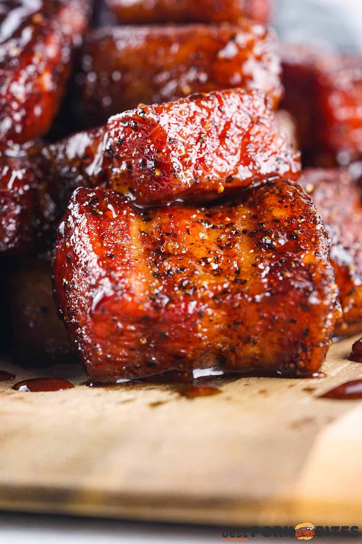 a closeup of slices of pork belly covered in rub and BBQ