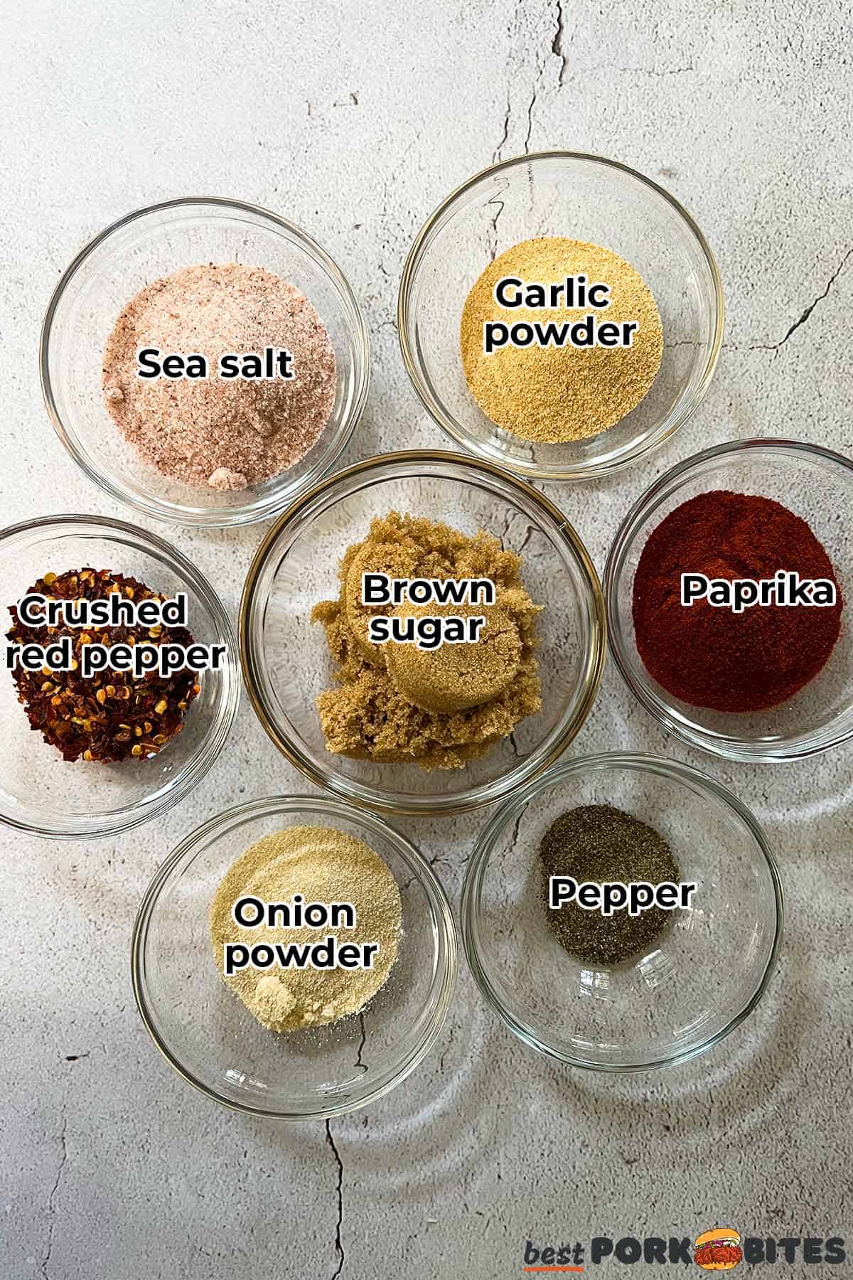 all the ingredients for pork chop seasoning in separate glass bowls with labels
