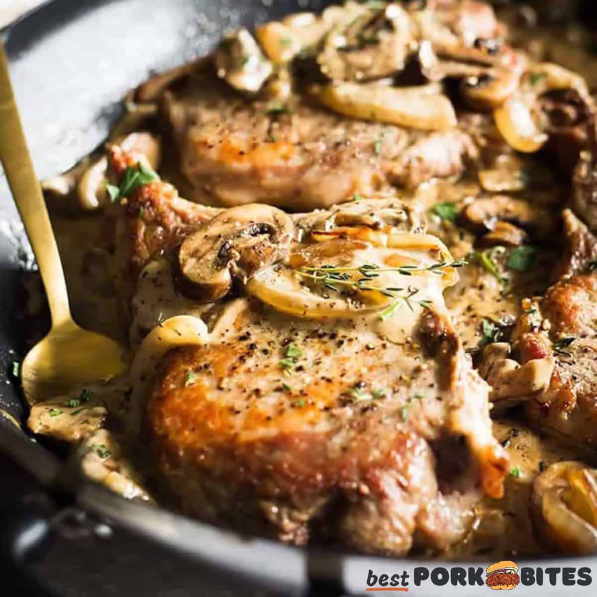 pork chops smothered with mushrooms up close in a black pan
