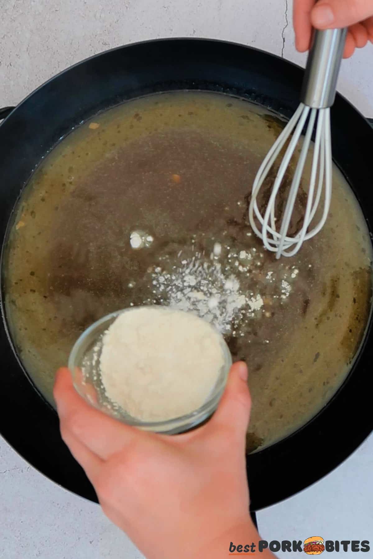 hands slowly pouring cornstarch into a pan of cooking gravy