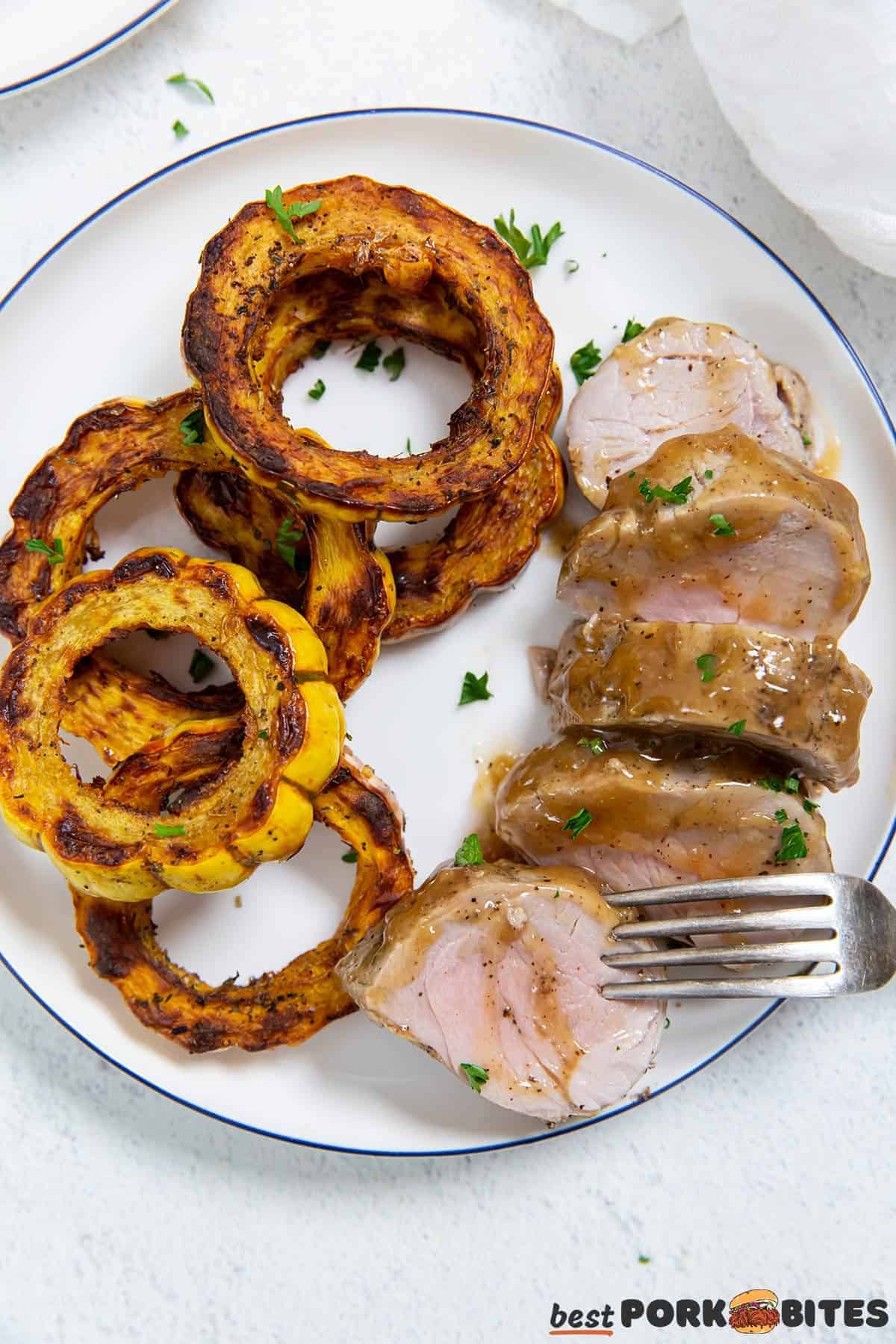 roasted squash and instant pot pork tenderloin on a white dinner plate with a fork