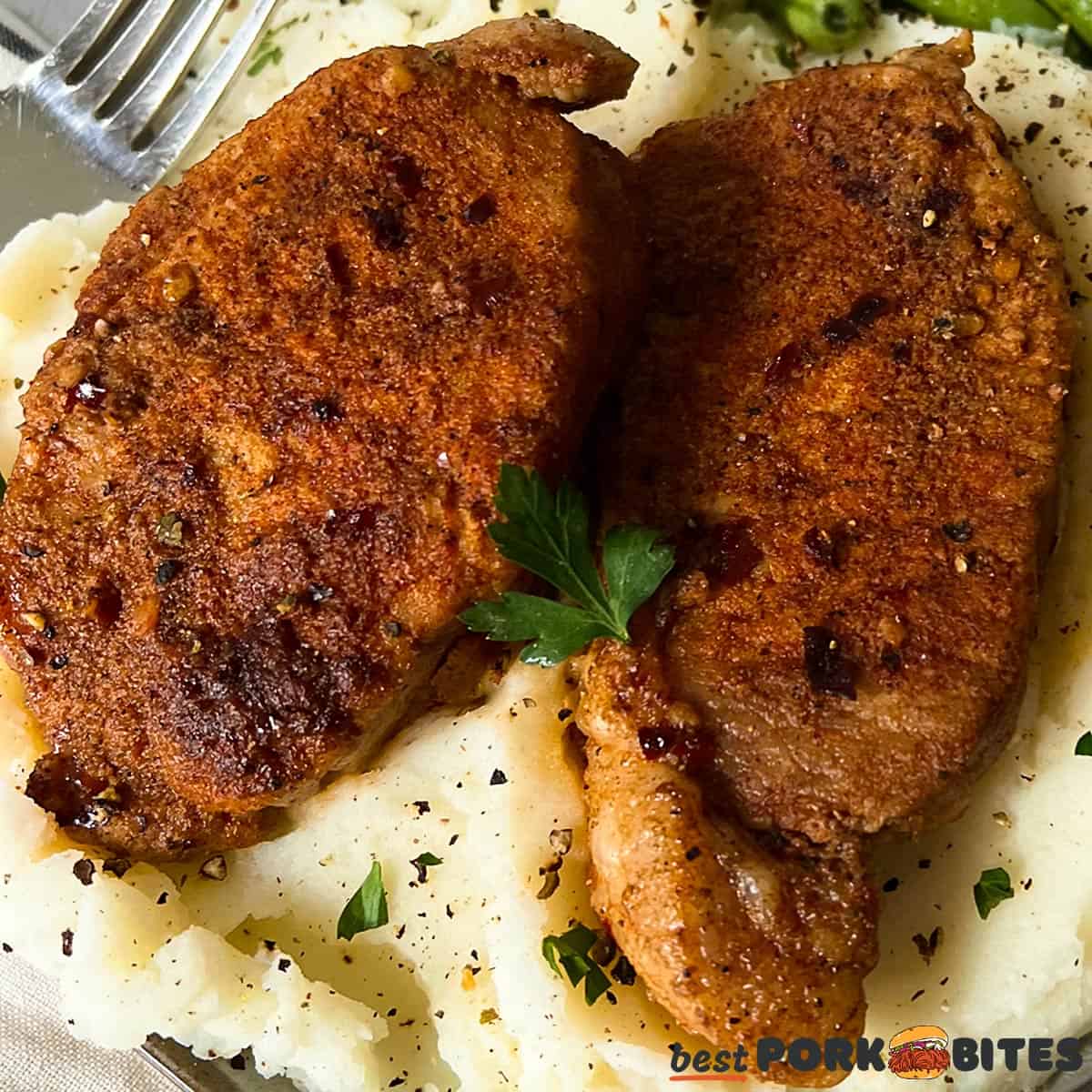 a closeup of two pressure cooked pork chops on mashed potatoes