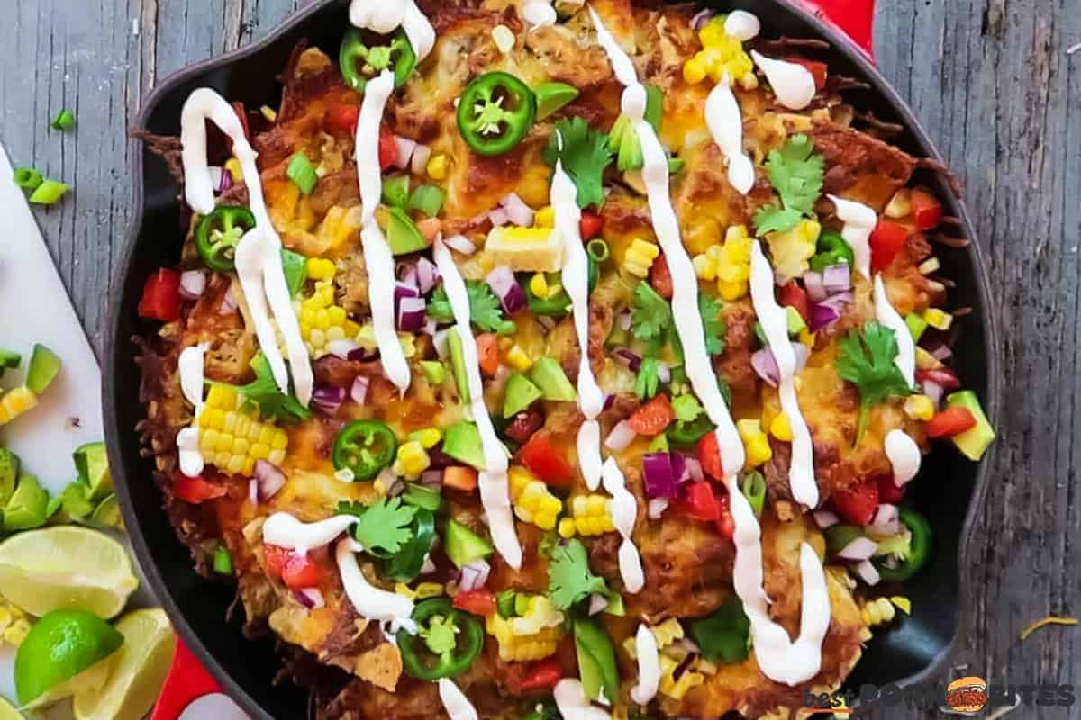 a skilled filled with baked nachos and covered in toppings
