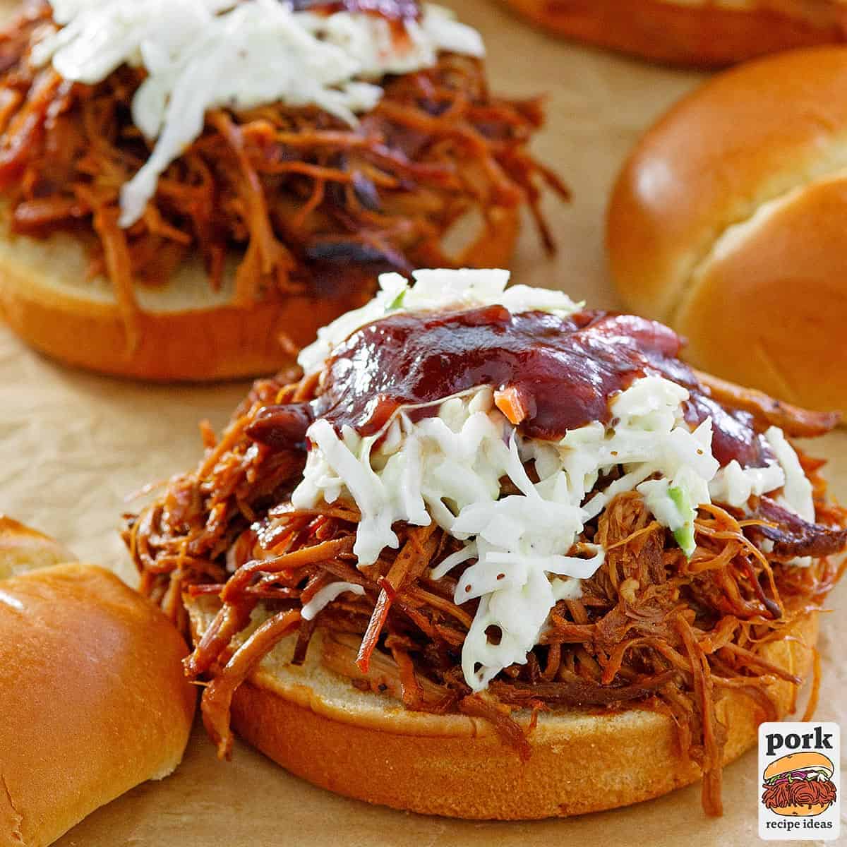 a pulled pork sandwich with coleslaw and extra bbq sauce
