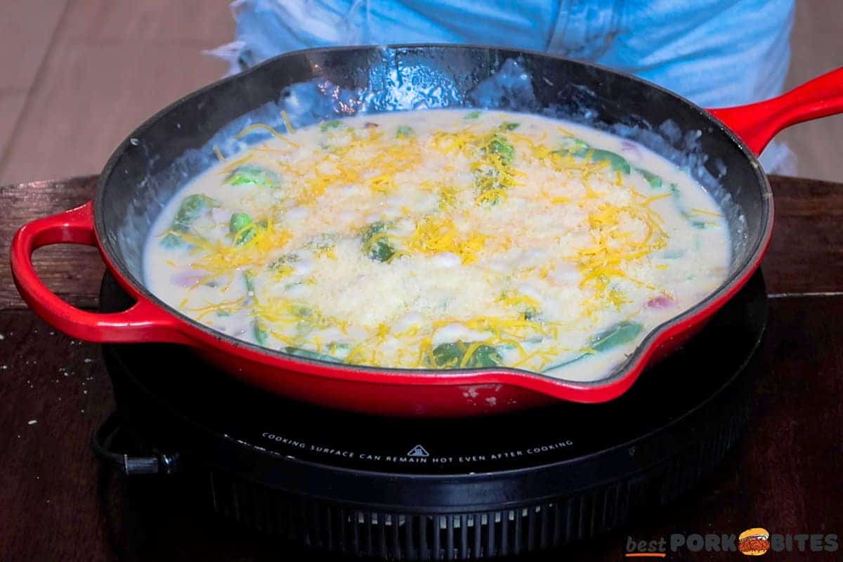 cheese added to a bubbling skillet of peppers and sauce