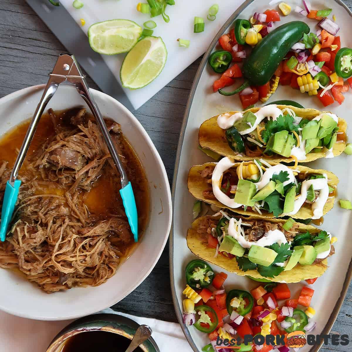 three slow cooker pork tacos on a platter next to a bowl of pulled pork and toppings ingredients