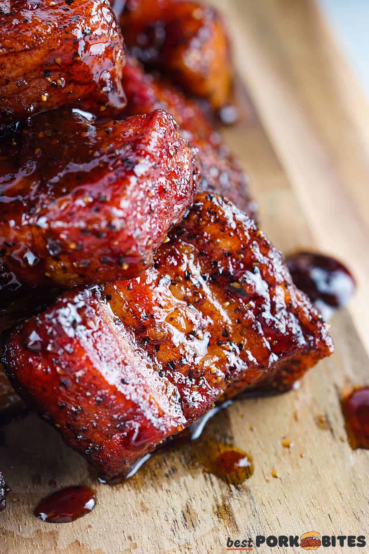 a closeup of pork belly burnt ends on a wooden cutting board