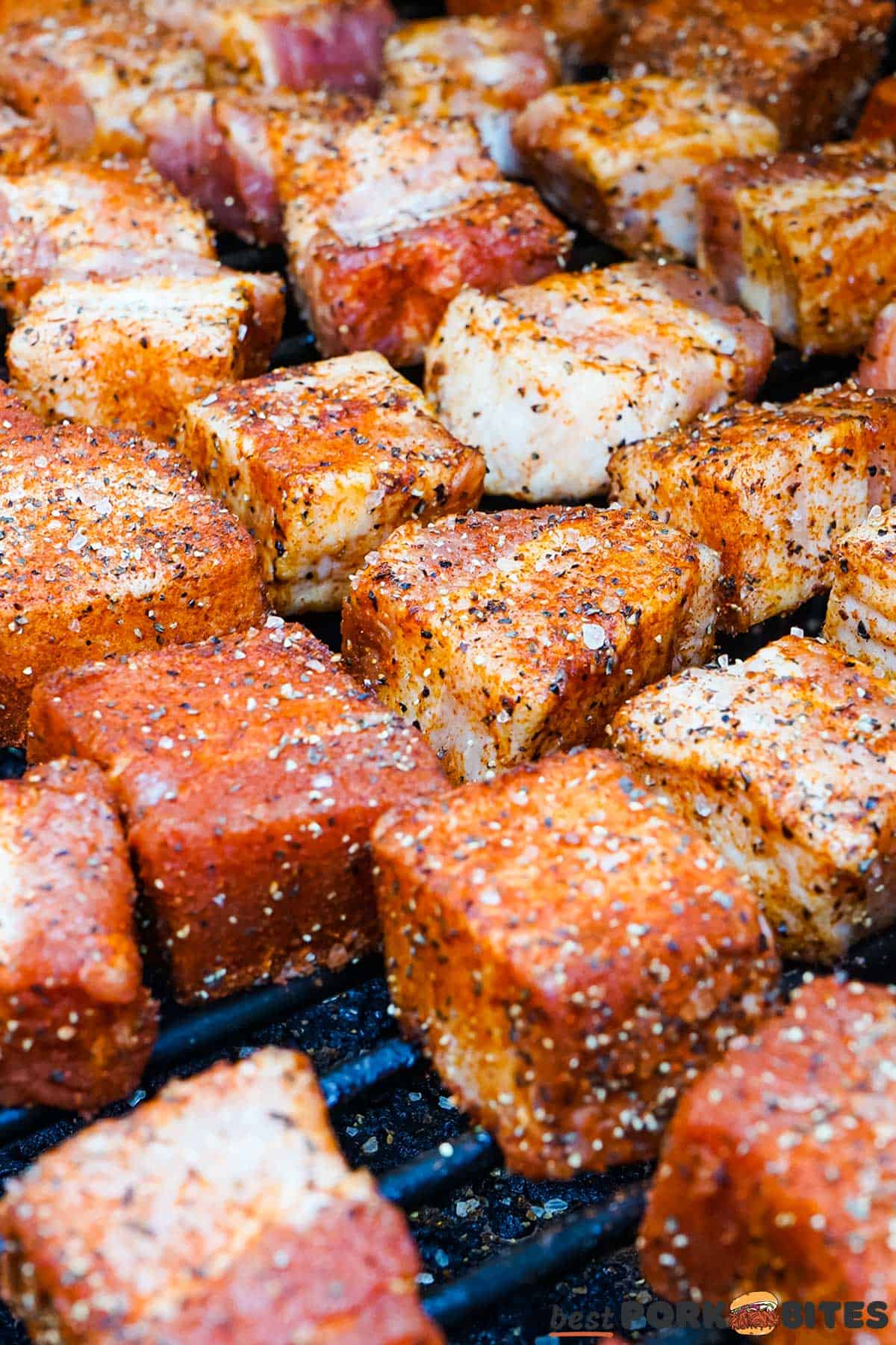 seasoned pork belly slices lined up in a smoker