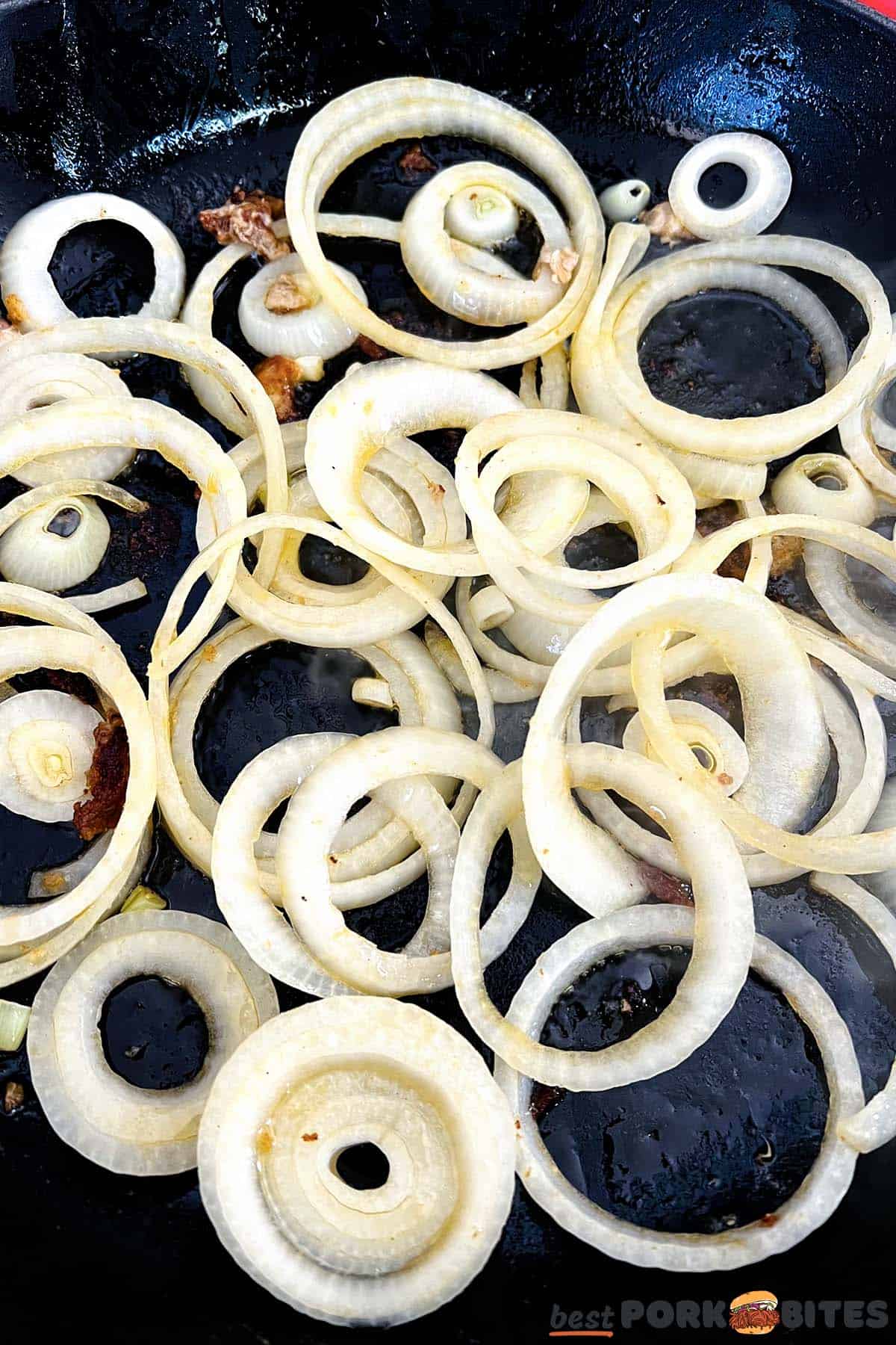 close up of onions cooking in a pan