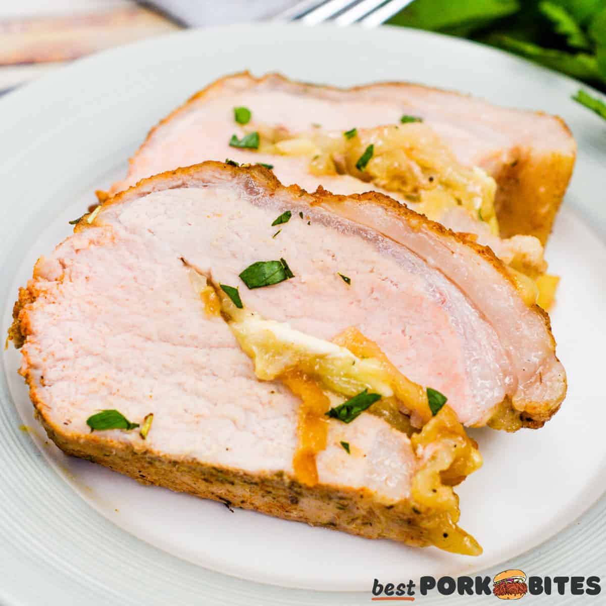 a white plate with two slices of stuffed pork tenderloin