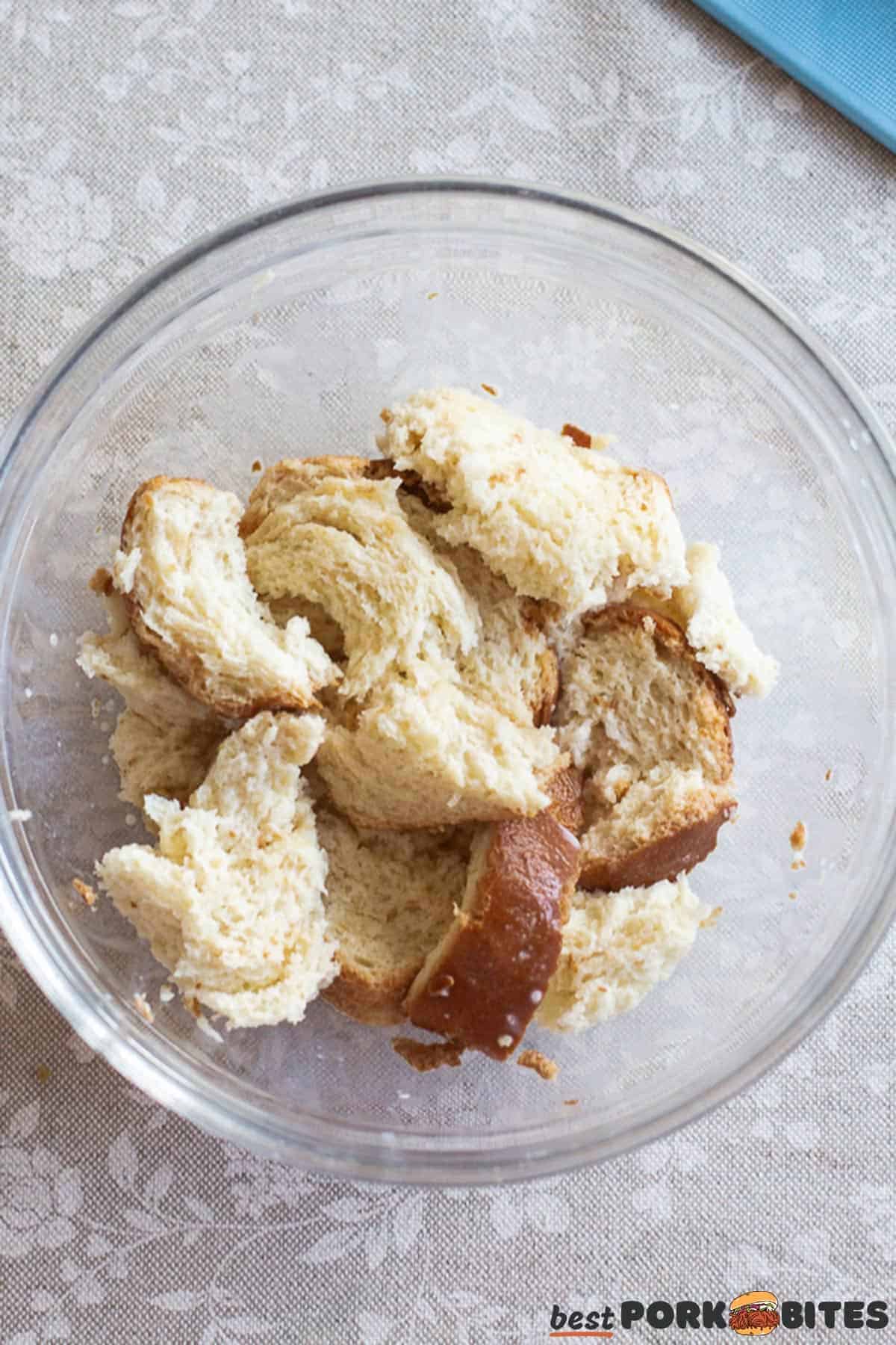 torn bread soaked in milk in a glass dish