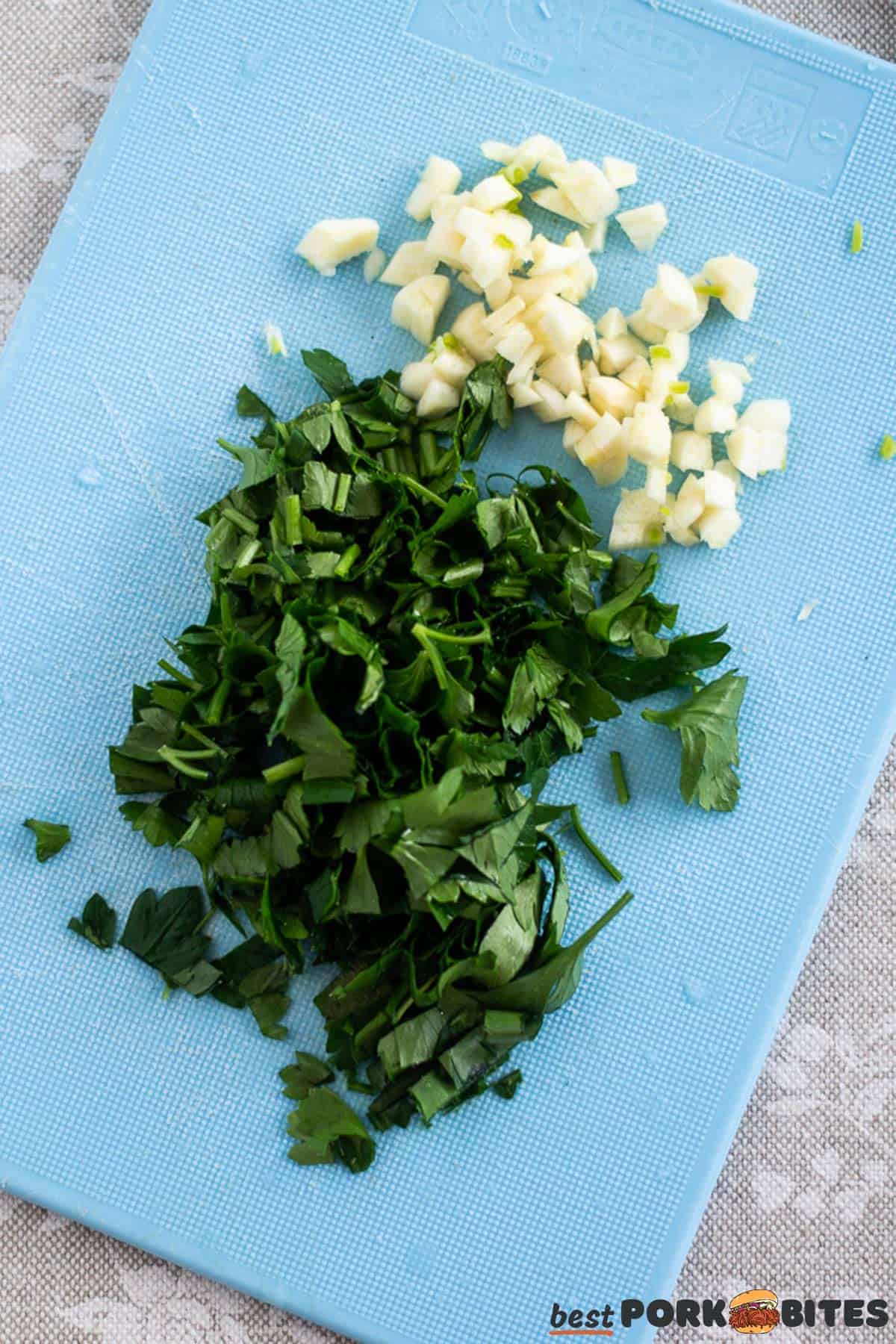 chopped parsley and garlic on a blue cutting board